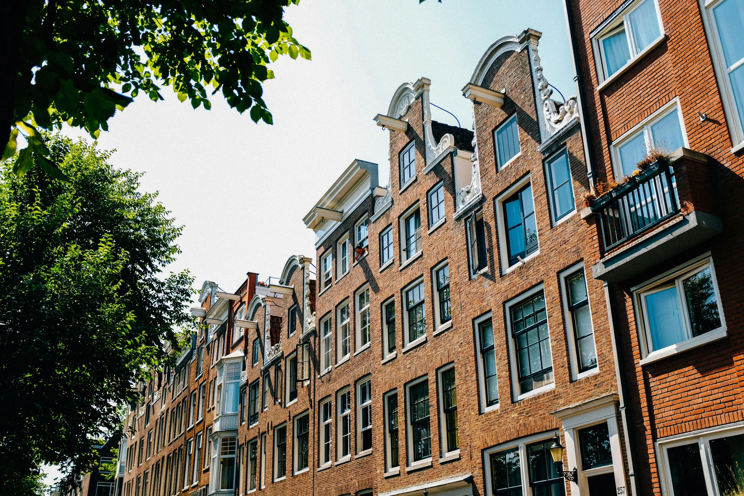 Karakteristieke straat in Amsterdam Oud-West met 19e-eeuwse panden en levendige winkels
